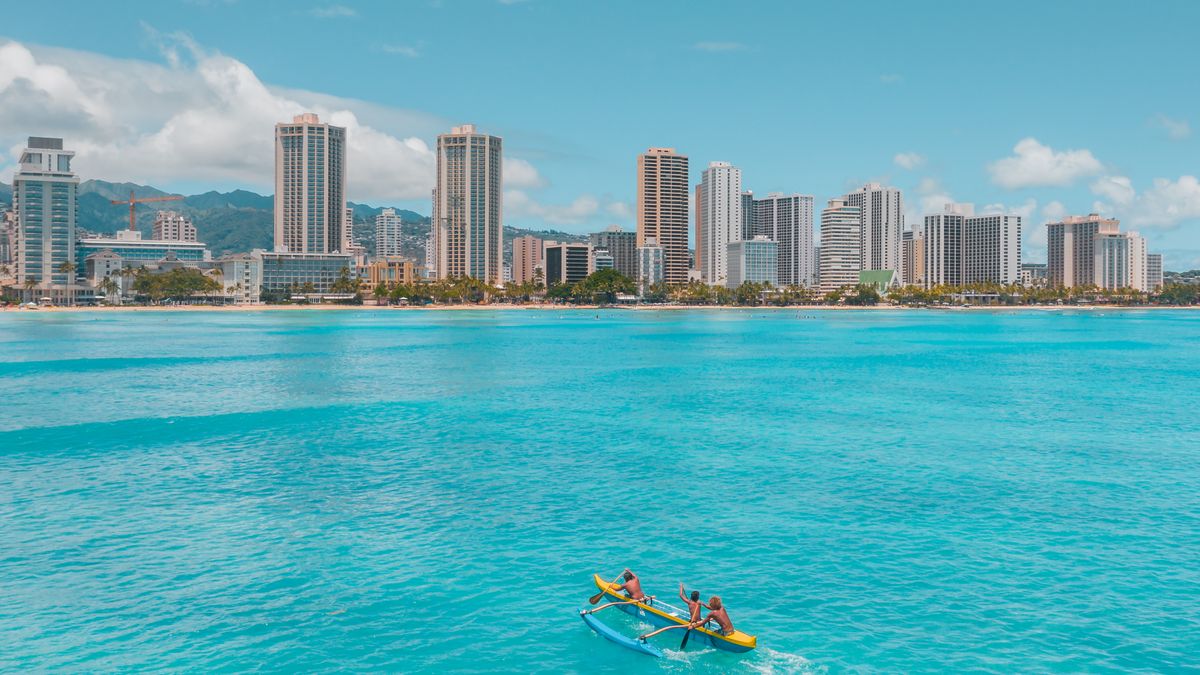 The Honolulu condo skyline seen from turquoise water off Waikiki